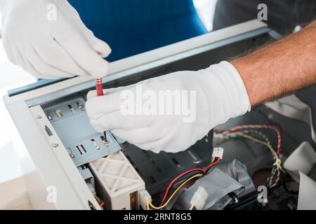 Nahaufnahme eines Technikers, der Handschuhe trägt, um den Computer zu reparieren Stockfoto