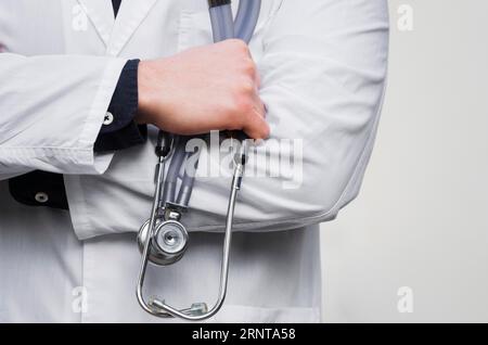 Männliche Arzthand mit Stethoskophand vor weißem Hintergrund Stockfoto