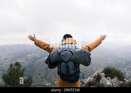Weiblicher Rucksacktouristen, der auf dem Gipfel des Berges steht und die Natur liebt Stockfoto