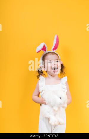 Kleines Mädchen Hase Ohren mit Kaninchen zeigen Zunge Stockfoto