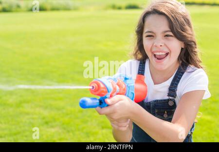 Smiley Mädchen spielt mit Wasserpistole Stockfoto