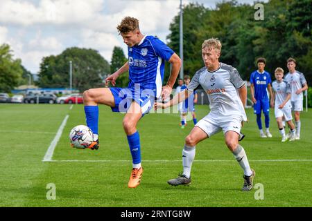 Swansea, Wales. 2. September 2023. Trey George aus Cardiff City schirmt den Ball während des Spiels der U18 Professional Development League Cup zwischen Swansea City und Cardiff City an der Swansea City Academy in Swansea, Wales, UK am 2. September 2023 vor Jacob Cook aus Swansea City ab. Quelle: Duncan Thomas/Majestic Media/Alamy Live News. Stockfoto