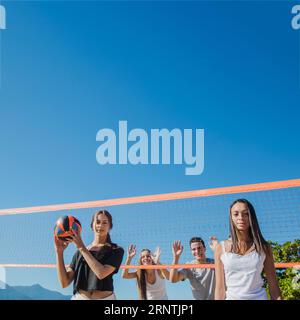 Gruppenfreunde spielen Beachvolleyball Stockfoto