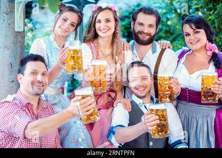 Eine Gruppe fröhliche Leute, die Bier trinken und in die Kamera schauen Stockfoto