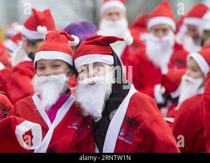 (171119) -- HAMILTON (KANADA), 19. November 2017 -- zwei Kinder posieren für Fotos beim Santa 5K-Lauf 2017 in Hamilton, Ontario, Kanada, am 19. November 2017. Mehr als 500 als Weihnachtsmann verkleidete Teilnehmer nahmen an dieser jährlichen Veranstaltung am Sonntag Teil. ) KANADA-HAMILTON-SANTA 5 km LAUF ZouxZheng PUBLICATIONxNOTxINxCHN Stockfoto