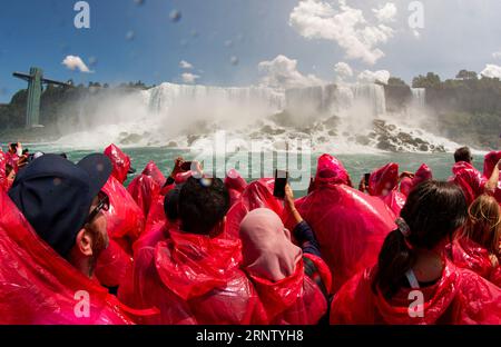 Niagarafälle, New Yok, USA - 1. August 2023: Nahaufnahme von Touristen an den Niagarafällen in roter Regenkleidung auf einem Ausflugsboot, das Fotos von den Amerikanern und macht Stockfoto