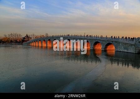 (171130) -- PEKING, 30. Nov. 2017 -- Foto aufgenommen am 29. Nov. 2017 zeigt Dämmerung durch die siebzehn Bogenbrücke im Sommerpalast in Peking, der Hauptstadt Chinas. ) (wf) CHINA-BEIJING-SUMMER PALACE (CN) LiuxXianguo PUBLICATIONxNOTxINxCHN Stockfoto