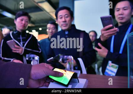 (171202) -- TONGXIANG, 2. Dezember 2017 -- Menschen beobachten ein flexibles OLED bei der Light of Internet Exposition der vierten Internet-Weltkonferenz in Wuzhen der Stadt Tongxiang in der ostchinesischen Provinz Zhejiang, 2. Dezember 2017. Auf der expo, die 411 renommierte Internetunternehmen aus dem in- und Ausland anzieht, werden die neuesten Internet-Technologien und -Anwendungen aus der ganzen Welt vorgestellt, wobei künstliche Intelligenz, Cloud-Computing, Big Data und andere Bereiche hervorgehoben werden. ) (Xzy) CHINA-TONGXIANG-DAS LICHT DER INTERNET EXPO (CN) LixXin PUBLICATIONxNOTxINxCHN Stockfoto