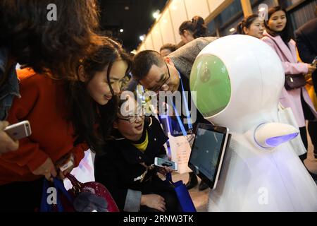 (171202) -- TONGXIANG, 2. Dezember 2017 -- Menschen interagieren mit einem Roboter auf der Light of Internet Exposition der vierten Internet-Weltkonferenz in Wuzhen, Tongxiang Stadt der ostchinesischen Provinz Zhejiang, 2. Dezember 2017. Auf der expo, die 411 renommierte Internetunternehmen aus dem in- und Ausland anzieht, werden die neuesten Internet-Technologien und -Anwendungen aus der ganzen Welt vorgestellt, wobei künstliche Intelligenz, Cloud-Computing, Big Data und andere Bereiche hervorgehoben werden. ) (Xzy) CHINA-TONGXIANG-DAS LICHT DER INTERNET EXPO (CN) ZhengxHuansong PUBLICATIONxNOTxINxCHN Stockfoto