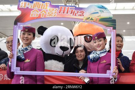 (171206) -- CHENGDU, 6. Dezember 2017 -- Stewardessen und Passagiere posieren für ein Gruppenfoto, um den Betrieb der Hochgeschwindigkeitsbahn zu feiern, die Xi an, die Hauptstadt der nordwestchinesischen Provinz Shaanxi, und Chengdu, die Hauptstadt der südwestchinesischen Provinz Sichuan, am Chengdudong Railway Station in Chengdu, 6. Dezember 2017 verbindet. Die Xi an-Chengdu-Hochgeschwindigkeitsstrecke wurde am Mittwoch in Betrieb genommen und verkürzte die Fahrzeit zwischen den beiden Städten von etwa 11 Stunden auf nur 4 Stunden. Die 658 Kilometer lange neue Strecke ist Chinas erste Eisenbahnstrecke, die durch die Qinling Mountains führt, die natürliche Grenze zwischen ihnen Stockfoto