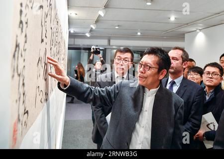 (171211) -- PARIS, 11. Dezember 2017 -- Zhang Xuguang (Front) stellt am 11. Dezember 2017 ein Stück seiner Kalligraphie im Hauptquartier der Organisation der Vereinten Nationen für Bildung, Wissenschaft und Kultur (UNESCO) in Paris, Frankreich, vor. Die "Aspirating to Peace"--Zhang Xuguangs kursive Kalligraphie-Ausstellung begann hier am Montag. Etwa 50 Stücke chinesischer Kalligraphie von Zhang Xuguang grüßen die Besucher bis 16. Dezember. ) FRANKREICH-PARIS-UNESCO-CHINESISCHE KALLIGRAPHIE-AUSSTELLUNG CHENXYICHEN PUBLICATIONXNOTXINXCHN Stockfoto