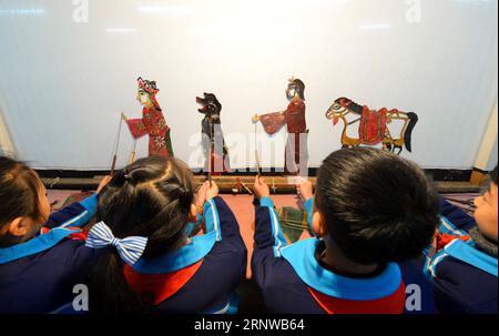 (171212) -- SHIJIAZHUANG, 12. Dezember 2017 -- Schüler spielen Schattenpuppen an einer Grundschule im Bezirk Hanshan von Handan, Provinz Hebei, Nordchina, 11. Dezember 2017. Die Schule lädt regelmäßig Schattenpuppenkünstler ein, das Interesse der Schüler an traditioneller Kultur zu fördern.) (Xzy) CHINA-SHIJIAZHUANG-SHADOW PUPPET (CN) WangxXiao PUBLICATIONxNOTxINxCHN Stockfoto