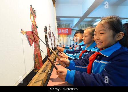 (171212) -- SHIJIAZHUANG, 12. Dezember 2017 -- Schüler spielen Schattenpuppen an einer Grundschule im Bezirk Hanshan von Handan, Provinz Hebei, Nordchina, 11. Dezember 2017. Die Schule lädt regelmäßig Schattenpuppenkünstler ein, das Interesse der Schüler an traditioneller Kultur zu fördern.) (Xzy) CHINA-SHIJIAZHUANG-SHADOW PUPPET (CN) WangxXiao PUBLICATIONxNOTxINxCHN Stockfoto