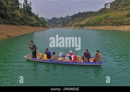 (171217) -- RONGJIANG, 17. Dezember 2017 -- Dorfbewohner nehmen ein Fährboot mit frisch geernteten Nabelorangen in Rongjiang County von Miao-Dong Autonome Präfektur Qiandongnan, Südwestchinesische Provinz Guizhou, 17. Dezember 2017. ) (wf) CHINA-GUIZHOU-ORANGES-HARVEST (CN) LiuxXu PUBLICATIONxNOTxINxCHN Stockfoto