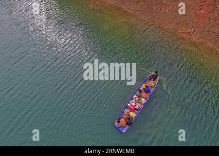 (171217) -- RONGJIANG, 17. Dezember 2017 -- Dorfbewohner nehmen ein Fährboot mit frisch geernteten Nabelorangen in Rongjiang County von Miao-Dong Autonome Präfektur Qiandongnan, Südwestchinesische Provinz Guizhou, 17. Dezember 2017. ) (wf) CHINA-GUIZHOU-ORANGES-HARVEST (CN) LiuxXu PUBLICATIONxNOTxINxCHN Stockfoto