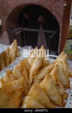 Marrakesch, Marokko - 10. Februar 2023: Marokkanische frittierte Samosas, ein beliebter Imbiss auf der Straße, auf dem Markt von Medina erhältlich Stockfoto