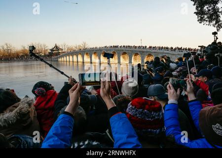 (171221) -- PEKING, 21. Dezember 2017 -- Menschen machen Fotos von der Dämmerung durch die siebzehn Bogenbrücke im Sommerpalast in Peking, Hauptstadt von China, 21. Dezember 2017. ) (Xzy) CHINA-PEKING-SOMMER-PALAST-LANDSCHAFT (CN) ZhangxCheng PUBLICATIONxNOTxINxCHN Stockfoto