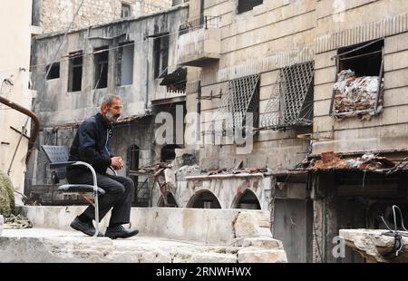 (171221) -- ALEPPO, 21. Dezember 2017 -- Maher Khayata, ein 60-jähriger Mann, sitzt am 21. Dezember 2017 auf dem Dach eines zerrütteten Einkaufszentrums in der Altstadt von Aleppo, Nordsyrien. Khayata ist der Hüter eines Einkaufszentrums. Er hat sein Leben damit verbracht, das Gelände zu schützen und dafür zu sorgen, dass es sicher bleibt. Als der Krieg sein Leben erschütterte und alles in Trümmer zerquetschte, blieb er dort und bewachte jede Erinnerung an ihn mit jedem fallenden Felsen in der Altstadt. Das Foto geht mit dem artikel Feature: Syrischer alter Mann wacht vom Krieg zerrüttetes Einkaufszentrum in Aleppos Altstadt. SYRIEN-ALEPPO-DESTRUC Stockfoto