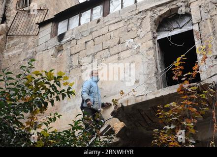 (171221) -- ALEPPO, 21. Dezember 2017 -- Maher Khayata, ein 60-jähriger Mann, klettert am 21. Dezember 2017 eine prekäre Leiter über die zerstörte Treppe zu seinem Haus auf dem Dach eines zerbrochenen Einkaufszentrums in der Altstadt von Aleppo, Nordsyrien. Khayata ist der Hüter eines Einkaufszentrums. Er hat sein Leben damit verbracht, das Gelände zu schützen und dafür zu sorgen, dass es sicher bleibt. Als der Krieg sein Leben erschütterte und alles in Trümmer zerquetschte, blieb er dort und bewachte jede Erinnerung an ihn mit jedem fallenden Felsen in der Altstadt. Auf dem Foto steht der artikel Feature: Syrischer alter Mann wacht im Krieg Stockfoto