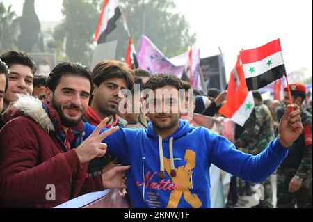 (171221) -- ALEPPO (SYRIEN), 21. Dezember 2017 -- Menschen halten syrische Nationalflaggen während der Jubiläumsfeier der Befreiung Aleppos auf dem Saadallah al-Jabiri-Platz in Aleppo, Nordsyrien, am 21. Dezember 2017. Die Jubiläumsfeier beinhaltete auch eine Militärparade und die Familien der Märtyrer, die während des Krieges ihr Leben verloren haben, indem sie Plakate mit Fotos ihrer getöteten Söhne und Verwandten hochhielten. Die Schlacht von Aleppo im vergangenen Jahr war ein Wendepunkt im Verlauf der Maßnahmen in der Syrienkrise, aufgrund der strategischen Bedeutung der Stadt, die das wirtschaftliche Zentrum war Stockfoto