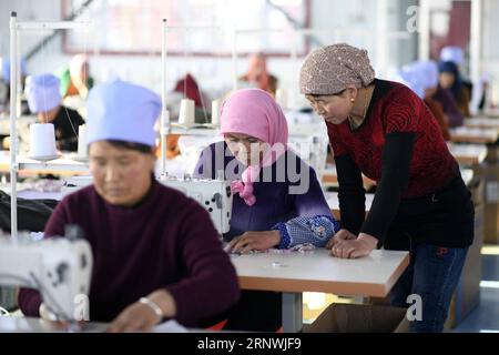 (171222) -- WUZHONG, 22. Dezember 2017 -- Dorfbewohner lernen während einer Ausbildung im Dorf Hantianling der Gemeinde Hexi, Stadt Wuzhong, Autonome Region Ningxia Hui, 21. Dezember 2017, Kleidung zu machen. Das Paar arbeitete für die Genossenschaft mit einem Jahreseinkommen von über 100.000 Yuan (15.209 US-Dollar). Hantianling, im Chinesischen der Berg der Dürre, liegt in der abgelegenen Bergregion von Ningxia. Die jährliche Verdunstung beträgt hier mehr als 2.000 mm, während die jährliche Niederschlagsmenge nur etwa 200 mm beträgt. Die Dürre war immer die größte Bedrohung für die Menschen vor Ort gewesen. Es gab nie genug Stockfoto