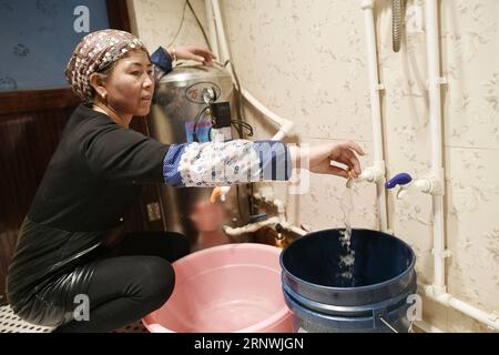 (171222) -- WUZHONG, 22. Dezember 2017 -- Villager Ma Xiaolan sammelt Leitungswasser zu Hause im Hantianling Village of Hexi Township, Stadt Wuzhong, Autonome Region Ningxia Hui, 21. Dezember 2017. Brunnen waren früher Trinkwasserquellen für Hantianling-Dorfbewohner, die 2013 in andere lebenswertere Orte umgesiedelt wurden. Hantianling, im Chinesischen der Berg der Dürre, liegt in der abgelegenen Bergregion von Ningxia. Die jährliche Verdunstung beträgt hier mehr als 2.000 mm, während die jährliche Niederschlagsmenge nur etwa 200 mm beträgt. Die Dürre war immer die größte Bedrohung für die Menschen vor Ort gewesen. Da Ist Er Stockfoto
