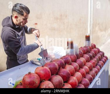 Marrakesch, marokkanisch - 6. Februar 2023: Ein Händler verkauft frisch gepressten Granatapfelsaft von einem Stand auf dem Souk-Markt Stockfoto