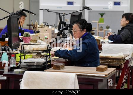 (171222) -- CHENGDU, 22. Dezember 2017 -- Yuan Dongjue arbeitet in ihrem Labor mit jungen Werkstätten in der Sichuan Provincial Library in Chengdu, Hauptstadt der südwestchinesischen Provinz Sichuan, 21. Dezember 2017. Yuan Dongjue, ein 70-jähriger Experte für Reparaturen antiker Bücher, arbeitet seit 1983 im Ancient Books Repair Center der Sichuan Provincial Library an der Reparatur und Erhaltung antiker Bücher. In ihrer 34-jährigen Karriere hat Yuan etwa 200 wertvolle alte chinesische Bücher repariert, von denen einige bis vor 1.000 Jahren zurückreichen könnten. Die Reparaturarbeiten bestehen aus mehr als 10 verschiedenen Schritten. Um nur ein Stück zu reparieren Stockfoto