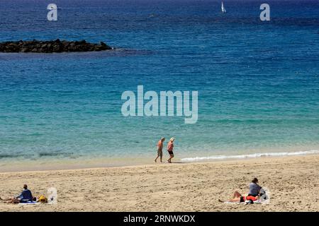 Älteres Paar, das entlang der Küste spaziert, Playa Blanca, Lanzarote, Kanarische Inseln, Spanien Stockfoto