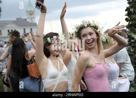 (171227) -- NEW YORK, 27. Dezember 2017 -- Menschen tanzen während des jährlichen Schwedischen Midsummer Festivals in Manhattan, New York, 23. Juni 2017. Bei dieser einzigartigen Feier treffen sich Erwachsene und Kinder, um im Gras zu picknicken, die Hochsommer-Stange zu dekorieren, Blumenkränze zu machen, traditionelle Spiele zu spielen und zu authentischer Geige-Musik zu tanzen. Von Las Vegas Shooting Spree bis zu Manhattans Truck Attack, von Texas Hurricane Harvey bis zu Kaliforniens Waldbränden, von der sich fortschreitenden Bull Stock Market bis hin zur einmaligen Sonnenfinsternis in den USA – siebzehn Fotos deckten die beeindruckenden Momente der Amerikaner durch Stockfoto