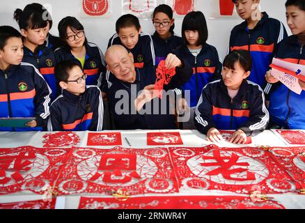 (171229) -- TANGSHAN, 29. Dezember 2017 -- Wang You (C Front), ein Papierschneider, unterrichtet Schüler an der experimentellen Mittelschule Hengqu im Luanxian County, Provinz Hebei, im Norden Chinas, 29. Dezember 2017. Die lokale Regierung hat Schulen dazu ermutigt, eine Papierschneideklasse zu eröffnen, um die traditionellen Kulturen der Jugend zu lehren. )(wjq) CHINA-HEBEI-PAPER CUTTING CULTURE (CN) MuxYu PUBLICATIONxNOTxINxCHN Stockfoto