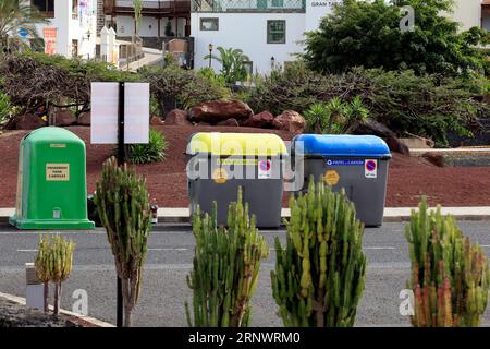 Bunte Mülltonnen und Recyclingstation, Bordsteinkante, Playa Blanca, Lanzarote, Kanarische Inseln, Spanien Stockfoto