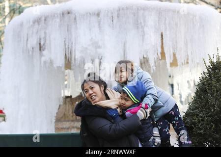 (180102) -- NEW YORK, 2. Januar 2018 -- Eine Frau hält am 2. Januar 2018 zwei Kinder vor einem gefrorenen Brunnen im Bryant Park in New York, USA. Die Menschen im Nordosten der Vereinigten Staaten hatten einen eisigen Anfang des neuen Jahres, da viele Städte am Dienstag eine Rekordtieftemperatur in Jahren verzeichneten. ) US-NEW YORK-LOW TEMPERATURE WangxYing PUBLICATIONxNOTxINxCHN Stockfoto