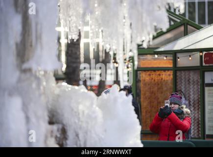 (180102) -- NEW YORK, 2. Januar 2018 -- Eine Frau fotografiert am 2. Januar 2018 einen gefrorenen Brunnen im Bryant Park in New York, USA. Die Menschen im Nordosten der Vereinigten Staaten hatten einen eisigen Anfang des neuen Jahres, da viele Städte am Dienstag eine Rekordtieftemperatur in Jahren verzeichneten. ) US-NEW YORK-LOW TEMPERATURE WangxYing PUBLICATIONxNOTxINxCHN Stockfoto