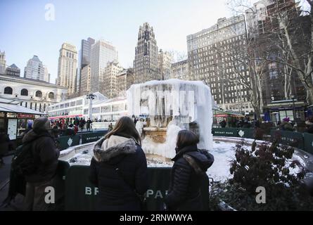 (180102) -- NEW YORK, 2. Januar 2018 -- die Leute schauen am 2. Januar 2018 auf einen gefrorenen Brunnen im Bryant Park in New York, USA. Die Menschen im Nordosten der Vereinigten Staaten hatten einen eisigen Anfang des neuen Jahres, da viele Städte am Dienstag eine Rekordtieftemperatur in Jahren verzeichneten. ) US-NEW YORK-LOW TEMPERATURE WangxYing PUBLICATIONxNOTxINxCHN Stockfoto