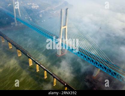 (180111) -- CHONGQING, 11. Januar 2018 -- die neue Baishatuo-Yangtze-Eisenbahnbrücke (oben) wird zusammen mit der früheren Baishatuo-Yangtze-Eisenbahnbrücke in Jiangjin der südwestchinesischen Gemeinde Chongqing, 9. Januar 2018 gesehen. Der Bau der neuen zweistöckigen Stahlfachwerkseilbrücke wurde vor kurzem abgeschlossen. Es verfügt über 4 Gleise auf dem Oberdeck für Personenzüge mit einer geplanten Geschwindigkeit von 200 Metern pro Stunde und 2 Gleise auf dem Unterdeck für Güterzüge mit einer geplanten Geschwindigkeit von 120 Kilometern pro Stunde. Die Gesamtlänge der Brücke beträgt 5,32 Kilometer, davon die Stockfoto