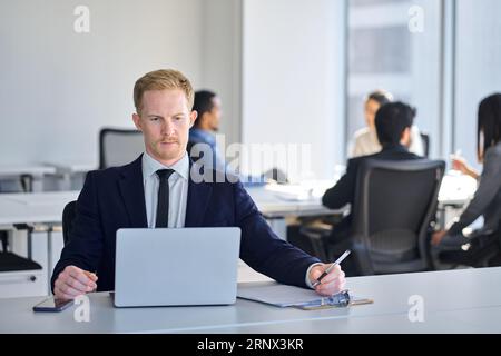 Geschäftiger Manager, der im Büro des Unternehmens Anzug trägt. Stockfoto