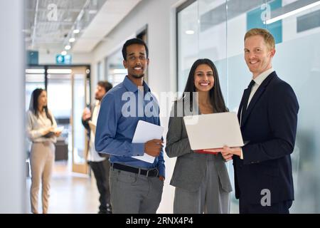 Professionelles, vielfältiges Team, junge Geschäftsleute, die im Büro stehen. Hochformat Stockfoto