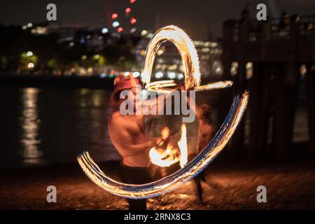 London, Großbritannien. September 2023. London Fire Spinners spielt an einem warmen Freitagabend an der Themse in Gabriel's Wharf dramatische Flame Acts. Guy Corbishley/Alamy Live News Stockfoto