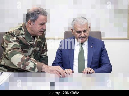 (180120) -- ANKARA, 20. Januar 2018 -- der türkische Premierminister Binali Yildirim (R) trifft am 20. Januar 2018 im Hauptquartier der türkischen Streitkräfte in Ankara mit dem türkischen Generalstabschef General Hulusi Akar zusammen. Der türkische Premierminister Binali Yildirim sagte am Samstag, dass türkische Kampfflugzeuge die Militäraktion gegen Afrin begonnen hätten, und fügte hinzu, dass das Ziel der Offensive darin bestehe, die Kämpfer der Kurdischen Demokratischen Union (PYD) und der Kurdischen Arbeiterpartei (PKK) zu eliminieren. TÜRKEI-ANKARA-SYRIEN-MILITÄROPERATION TurkschischxPrimexMinistry PUBLICATIONxNOTxINxCHN Stockfoto