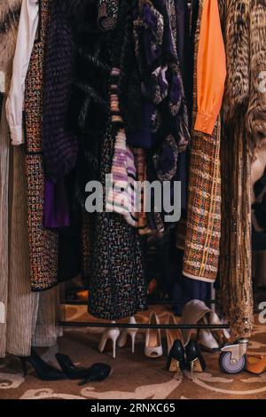 Frauentücher und Pelzmäntel hängen hintereinander auf der Backstage. Frauenmodekonzept Stockfoto