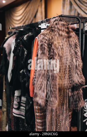 Wintermäntel aus Stoff für Damen, die hintereinander auf der modischen Backstage hängen Stockfoto