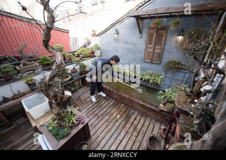 (180122) -- HANGZHOU, 22. Januar 2018 -- Qian Zhongshu putzt die Gartenterrasse seines Ateliers in Hangzhou, Hauptstadt der ostchinesischen Provinz Zhejiang, 22. Januar 2018. Qian wurde 1983 in Hangzhou geboren. Als Enthusiast der traditionellen chinesischen Kultur trat der Absolvent der China Academy of Art aus dem Amt zurück und eröffnete vor etwa neun Jahren sein eigenes Schmuckstudio. Bis jetzt hat seine Gruppe fast 20 Mitglieder. Sie können jedes Jahr mehr als 300 Schmuckstücke herstellen. )(mcg) CHINA-HANGZHOU-SCHMUCKHERSTELLER (CN) WengxXinyang PUBLICATIONxNOTxINxCHN Stockfoto