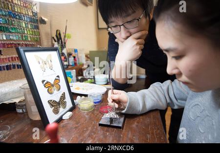 (180122) -- HANGZHOU, 22. Januar 2018 -- Qian Zhongshu (L) schaut auf seinen Handwerker, der ein Schmuckstück malte, das er in Hangzhou, der Hauptstadt der ostchinesischen Provinz Zhejiang, am 22. Januar 2018 entworfen hat. Qian wurde 1983 in Hangzhou geboren. Als Enthusiast der traditionellen chinesischen Kultur trat der Absolvent der China Academy of Art aus dem Amt zurück und eröffnete vor etwa neun Jahren sein eigenes Schmuckstudio. Bis jetzt hat seine Gruppe fast 20 Mitglieder. Sie können jedes Jahr mehr als 300 Schmuckstücke herstellen. )(mcg) CHINA-HANGZHOU-SCHMUCKHERSTELLER (CN) WengxXinyang PUBLICATIONxNOTxINxCHN Stockfoto