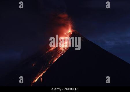 (180128) -- PEKING, 28. Januar 2018 -- die glühende Lava fließt aus dem Krater des Mayon-Vulkans, während er in der Albay-Provinz, den Philippinen, am 23. Januar 2018 ausbricht. ) (Djj) XINHUA FOTO WÖCHENTLICHE ENTSCHEIDUNGEN RouellexUmali PUBLICATIONxNOTxINxCHN Stockfoto