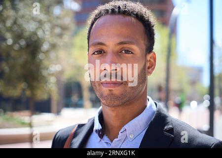 Nahaufnahme eines jungen erwachsenen Latino-Geschäftsmannes mit ernsthaftem Ausdruck. Kommerziell männlich formell Stockfoto