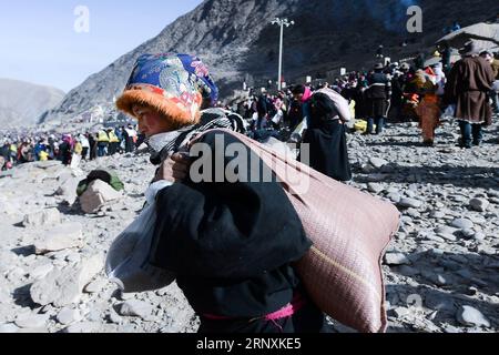 (180203) -- YUSHU, 3. Februar 2018 -- Menschen tibetischer ethnischer Gruppen tragen Sand auf dem gefrorenen Tongtian-Fluss in der tibetischen Autonomen Präfektur Yushu, Provinz Qinghai im Nordwesten Chinas, 2. Februar 2018. Die Menschen verwendeten Sand, um das sechssilbige Mantra OM Mani Padme Hum am Ufer des Tongtian River zu malen, um für das Glück zu beten. (lx) CHINA-QINGHAI-SAND-ICE(CN) WuxGang PUBLICATIONxNOTxINxCHN Stockfoto