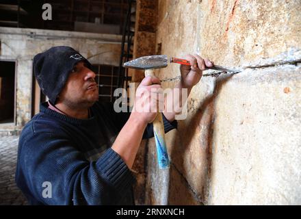 (180206) -- ALEPPO (SYRIEN), 6. Februar 2018 -- Ein syrischer Arbeiter restauriert am 6. Februar 2018 das antike Gebäude des Bab al-Nasr-Tores in der Altstadt von Aleppo, Syrien. Der Krieg zerstört Menschen und Häuser in Syrien, aber während der Zerstörung werden einige alte Geheimnisse enthüllt. Nach dem Krieg haben Restaurierungsbemühungen in den betroffenen antiken Stätten in Aleppo begonnen. Als Freiwillige ihre Arbeit im Bab al-Nasr-Tor begannen, wurden die Schichten, die auf den Steinboden und die Wände aufgebracht wurden, gebrochen und in einigen Teilen zerstört, was die ursprüngliche Struktur und Architektur des Tores und seines äußeren Teils offenbarte. ) Der Phot Stockfoto