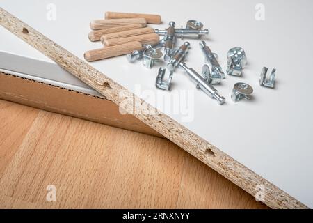 Ein Stapel von Teilen eines neuen Möbels, verschiedene Montagemöbelbeschläge. Stockfoto