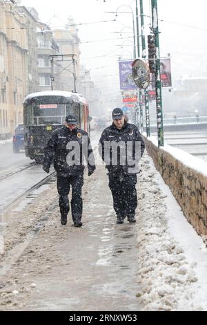 (180213) -- SARAJEVO, 13. Februar 2018 -- Polizisten gehen am 13. Februar 2018 in Sarajevo, Bosnien und Herzegowina im Schnee. Der Schneefall traf Sarajevo hier am Dienstag. )(srb) BOSNIEN UND HERZEGOWINA-SARAJEVO-SNOW HarisxMemija PUBLICATIONxNOTxINxCHN Stockfoto